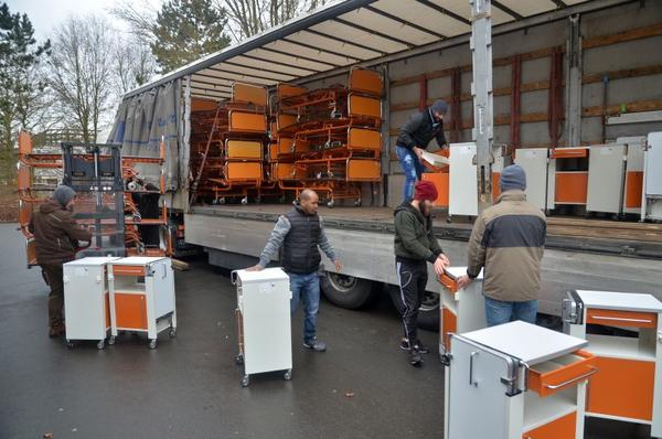 Beim Verladen von Mobiliar für das Krankenhaus in Ungarn helfen Flüchtlinge.